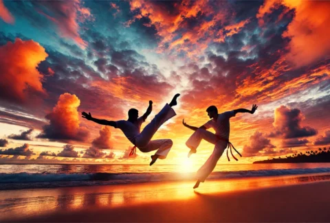 Two capoeiristas perform acrobatic kicks on a beach at sunset, silhouetted against a dramatic sky.