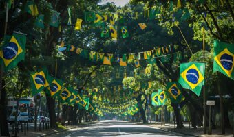 uma-rua-alinhada-por-arvores-com-bandeiras-que-dizem-clube-de-citacao