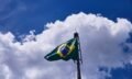 Low angle shot of the flag of Brazil under the beautiful clouds in the blue sky