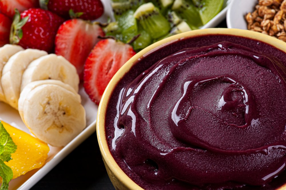 Brazilian açaí bowl with banana, strawberries, kiwi, orange and granola
