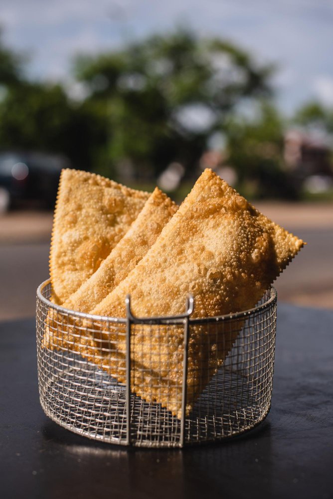 Crispy Brazilian pastéis served in a small metal basket