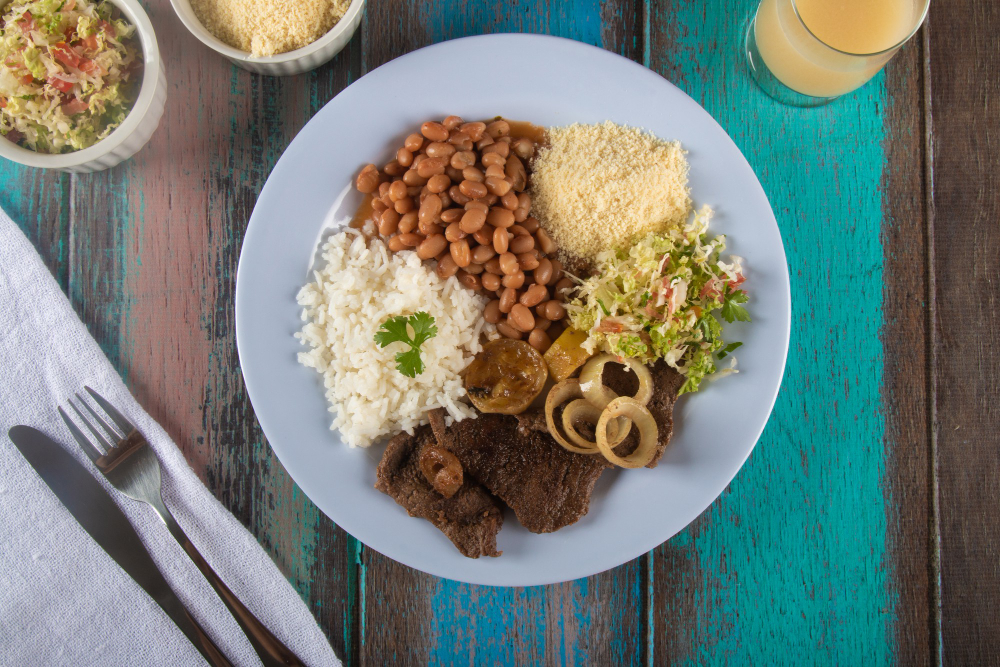 Brazilian prato feito with rice, beans, steak, farofa and salad
